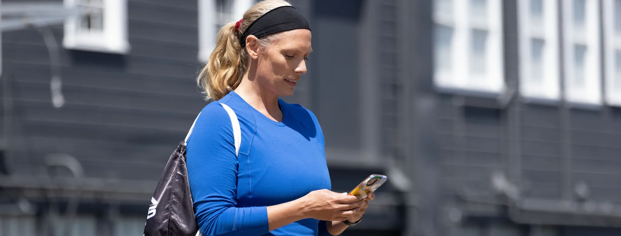 Woman in blue top looking at her phone