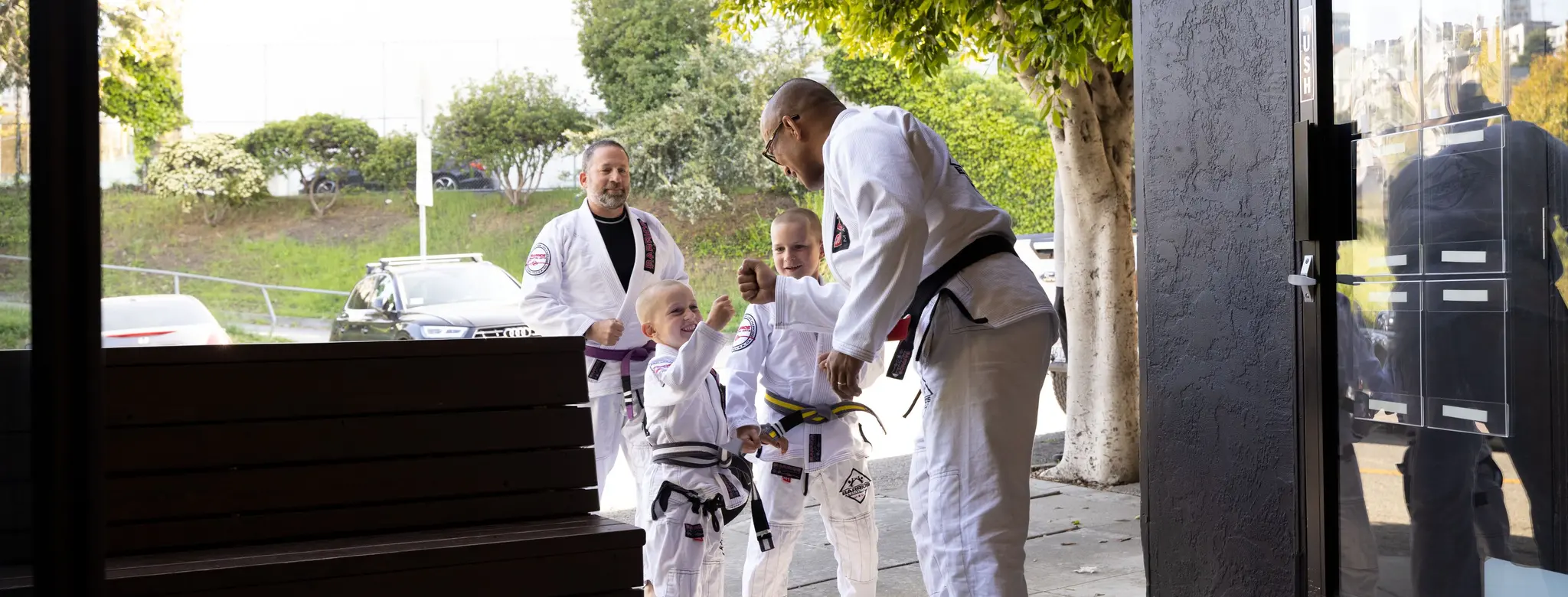 Young students greeting their instructor outside a martial arts academy