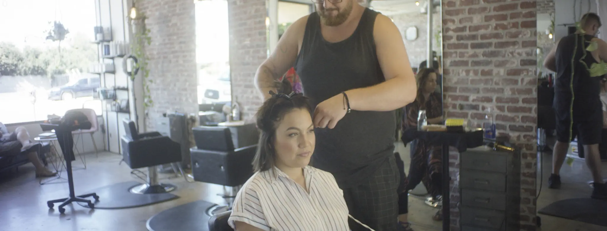 man cutting female client hair in salon