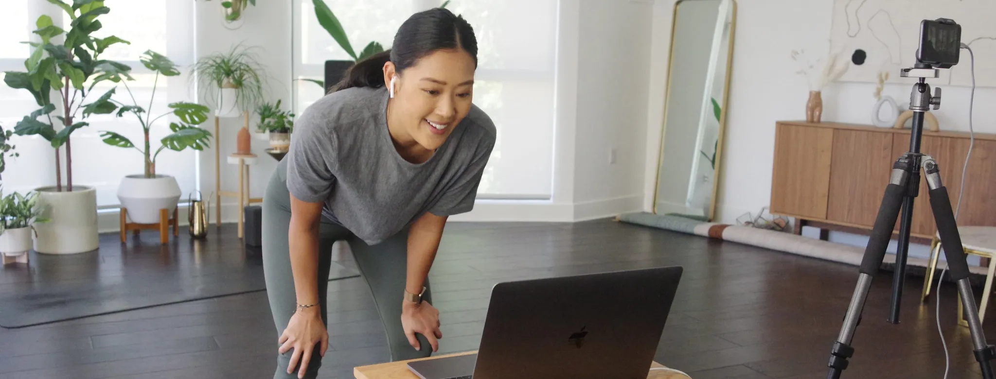 woman looking at laptop teaching yoga class