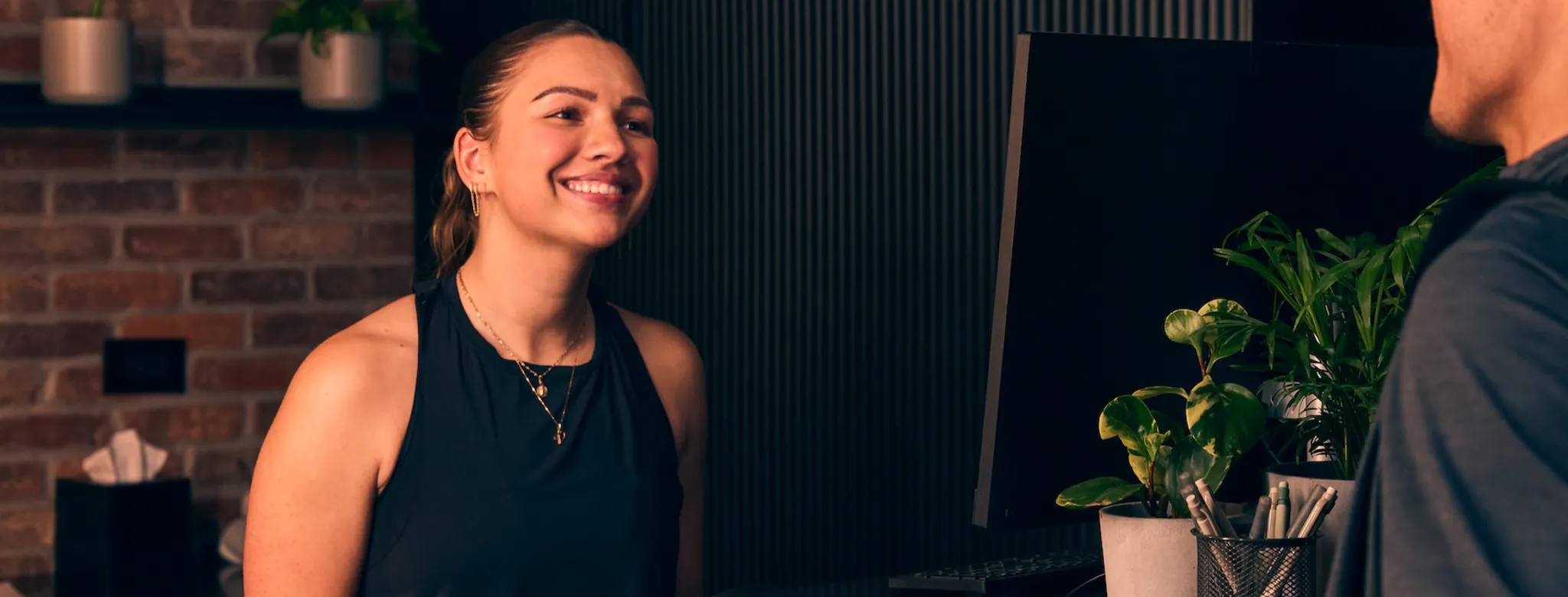 A client and staff member at the front desk of a fitness business.