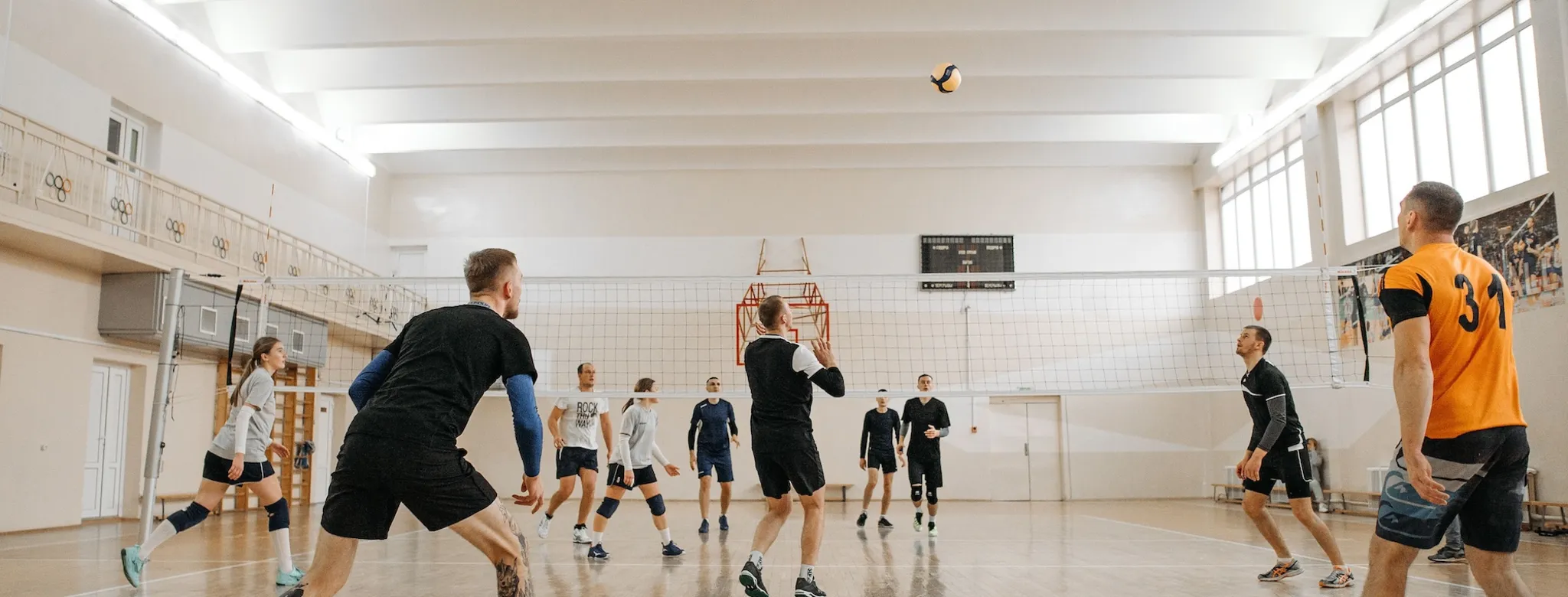 A group of people playing volleyball at a sports facility.