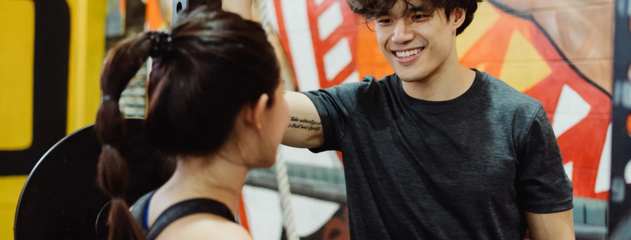 Two people talking at the gym.