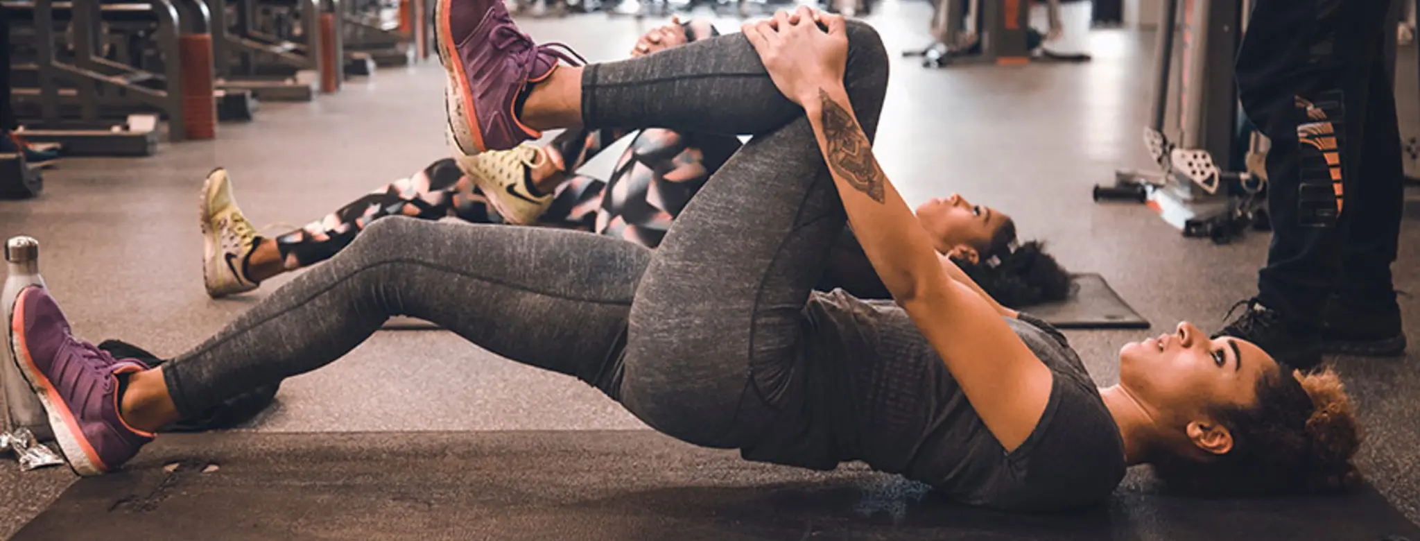 Two women exercising at a fitness studio with a trainer