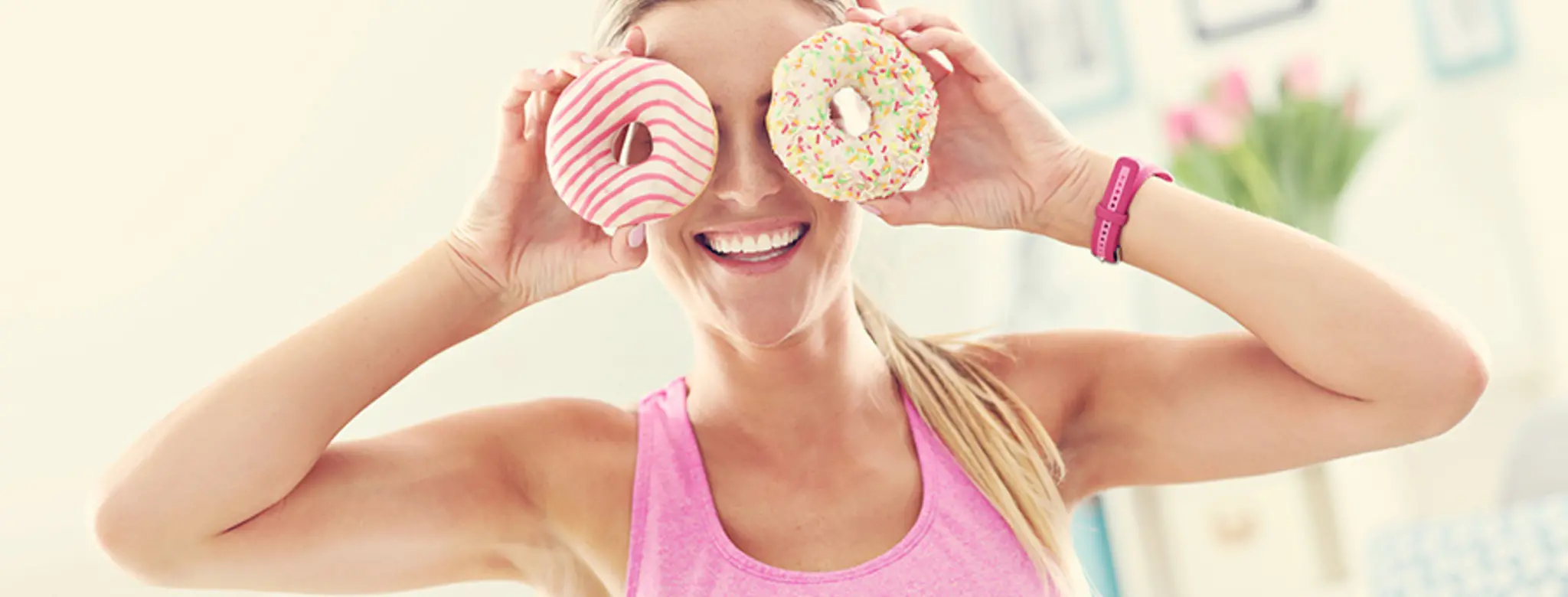 woman holding donuts to her eyes