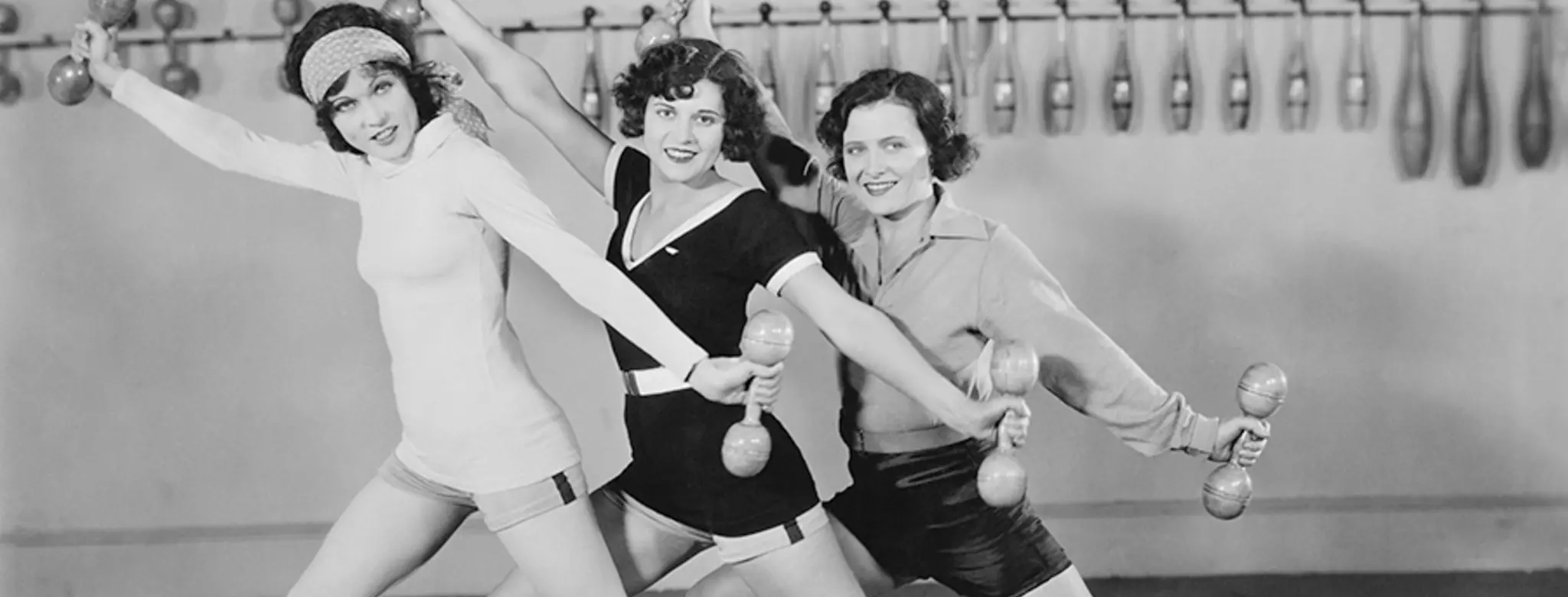 Three woman from the 1920s with vintage workout wear and weights