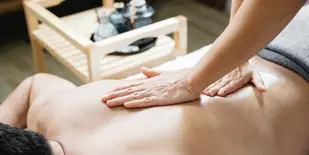 Hands of a massage therapist on the back of a client