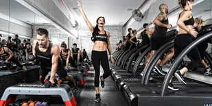 A fitness class at Shred 415 featuring weights and treadmills