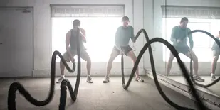 3 men work out using battle ropes