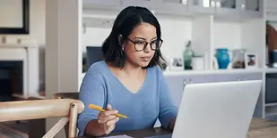 Woman working at desk with laptop