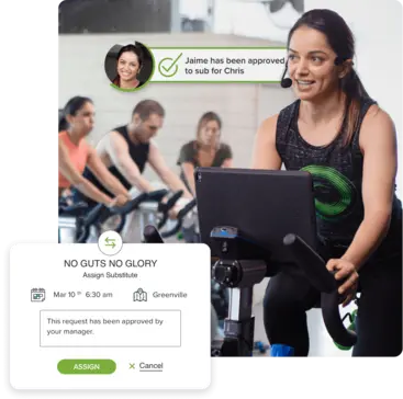 Spin class instructor with FitMetrix substitution screen in background